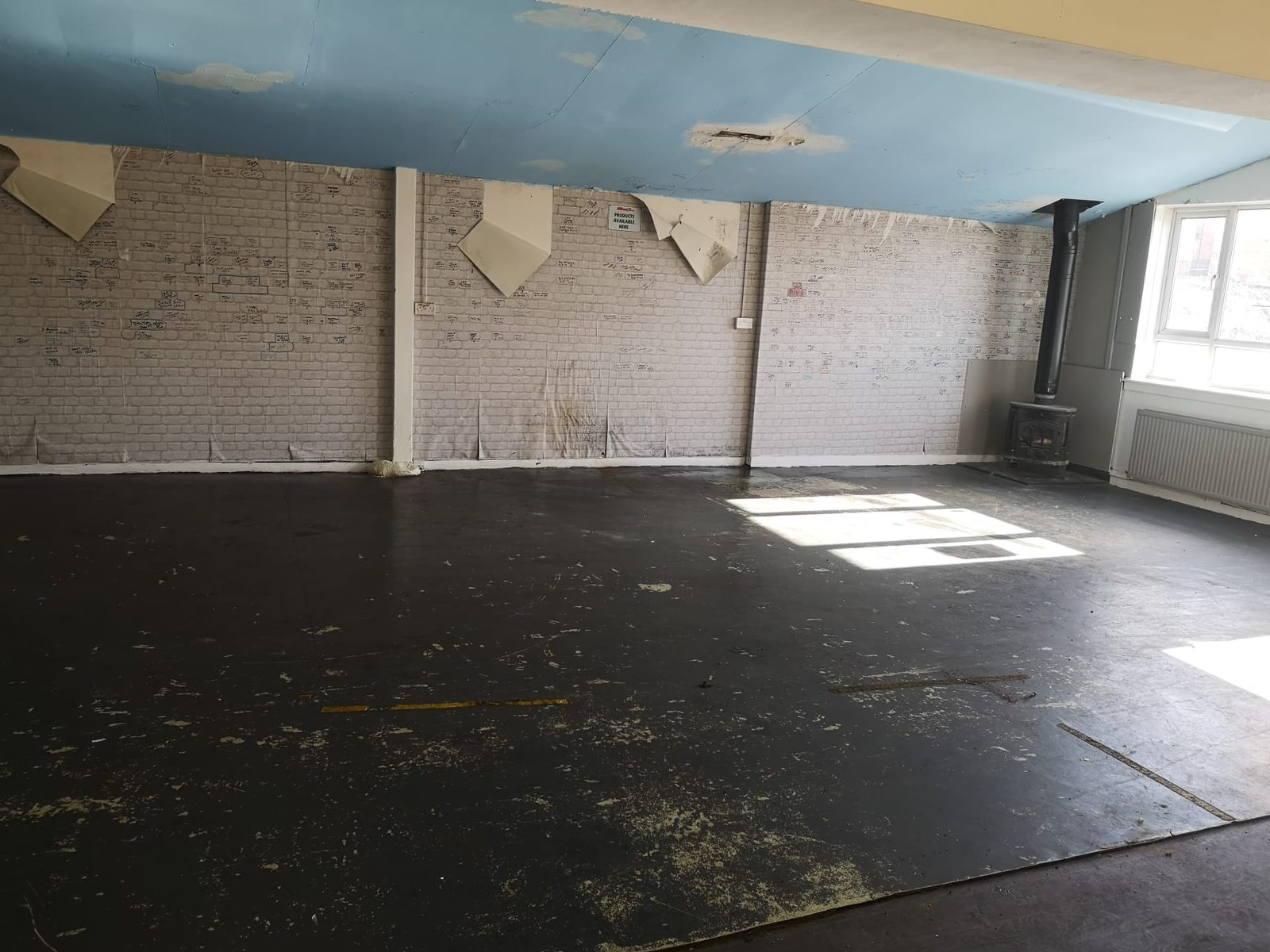 Commercial unit with damaged ceiling boards and worn flooring needing strip out before hand back